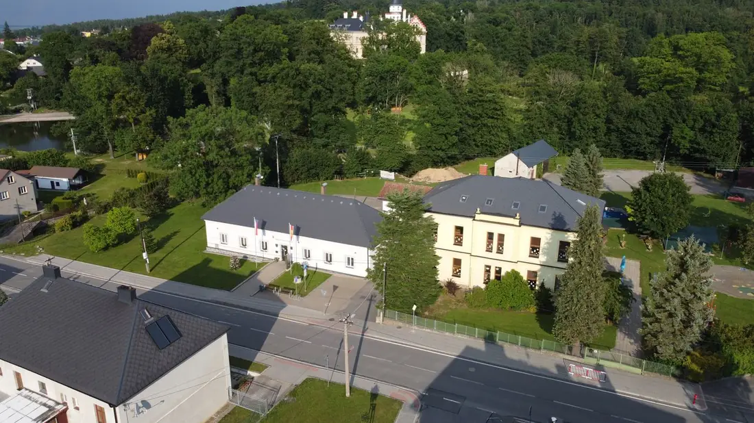Opravené historické školní budovy — obecní úřad a mateřská škola v centru obce, pohled z dronu.