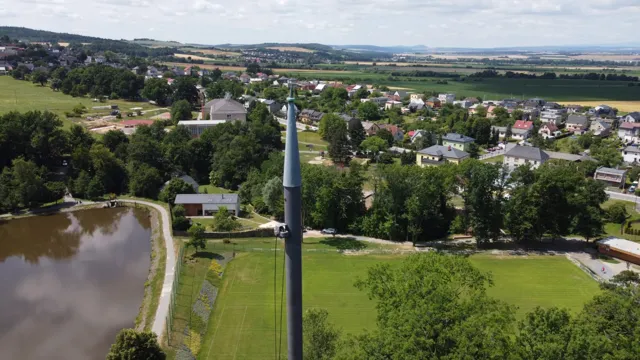 Letecký pohled od špice zámecké věže na obec Raduň s rybníkem, fotbalovým hřištěm a okolní krajinou.